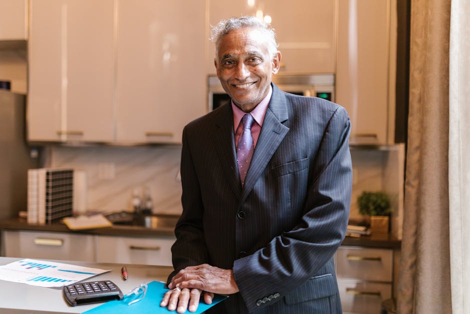 Senior businessman in suit smiling, standing in modern office with documents.